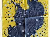 une écharpe carrée jaune et noire à pois