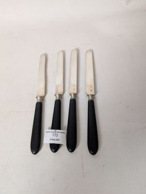 three black and white knives and a knife holder on a white surface