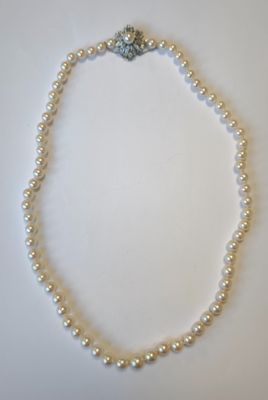 gros plan d'un collier de perles blanches sur une surface blanche