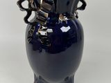 a blue vase with two handles sitting on a table