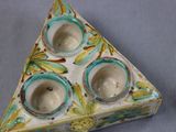 a triangle shaped tea light holder with three cups on it