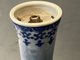 un vase bleu et blanc orné d'un anneau doré
