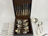 a wooden box with silverware in it on a white surface
