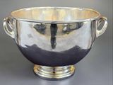 a large silver bowl with handles on a table