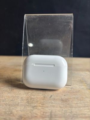 Des AirPods d'Apple sont posés sur une table en bois