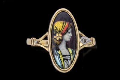 un gros plan sur une bague en or sur laquelle figure le portrait d'un homme portant un turban