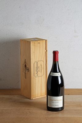 a bottle of wine next to a wooden box on a table