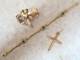 two pieces of jewelry are sitting on a table next to a cross