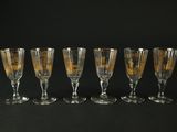 six verres à vin alignés sur un fond noir