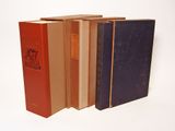several books are lined up in a row on a white surface