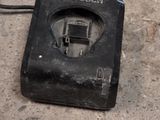 a small black object on the ground with a cord