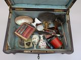 an open suitcase filled with assorted items on a white surface