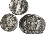 three ancient roman coins on a white background