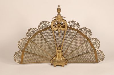 un ventilateur ancien en laiton orné d'un motif décoratif sur le dessus