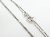 a close up of a silver chain on a white surface