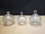 three clear glass vases sitting on top of a wooden table
