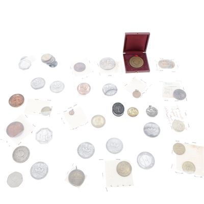 une boîte rouge remplie de pièces, posée sur une surface blanche