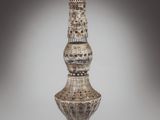 a tall vase that is made of wood and has a design on it
