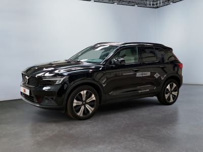Le SUV noir est garé dans une grande pièce aux murs blancs.