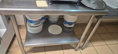 a metal table with two buckets of milk on it