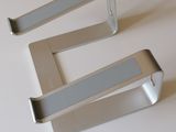 three metal hooks on a white surface
