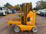 un petit chariot élévateur jaune garé sur un parking