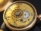 a close up of a gold pocket watch on a black surface