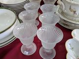 plusieurs assiettes et tasses sur une table avec une nappe rouge