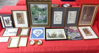 many framed pictures on a red table with a red table cloth