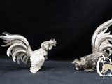 paire de figurines de coqs plaquées argent sur fond noir