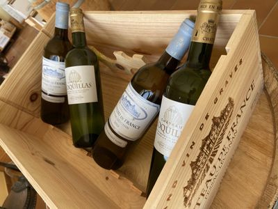 three bottles of wine in a wooden box on a table