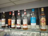 many bottles of alcohol sitting on a shelf next to glasses