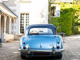 a blue car parked in front of a large house