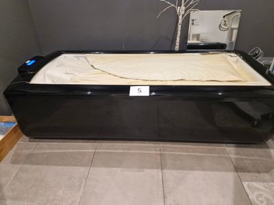 a black bath tub with a beige blanket on it