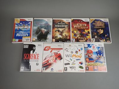 several video games are lined up on a table in front of a wall