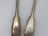 pair of silverware spoons on a white surface with a white background
