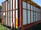 a red and white trailer parked in the grass