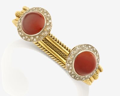 un gros plan sur une paire de bracelets en or et en corail
