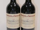 two bottles of wine sitting on top of a table next to each other