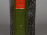 an old book with a green cover sitting on top of a table