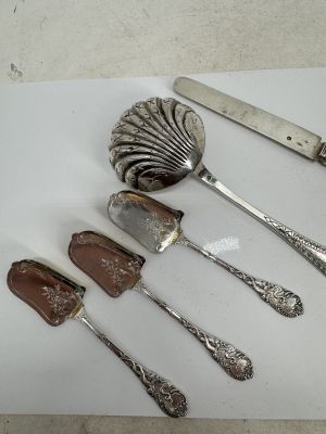 five spoons, a knife, and a spoon on a cutting board