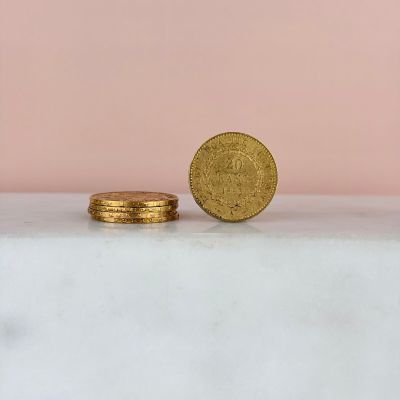 deux pièces d'or posées l'une à côté de l'autre sur une surface en marbre