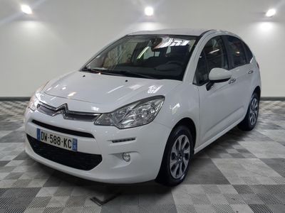 the small white car is parked on a checkered floor