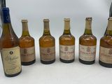 six bouteilles de vin sont alignées sur une table