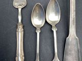 five spoons and two spoons sitting on a table