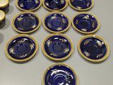 many plates and cups on the table with a teapot