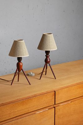 deux lampes posées sur une commode en bois devant un mur gris