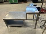 une table en métal surmontée d'une étagère, dans un entrepôt