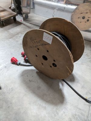 a spool with a wire on the floor in a room