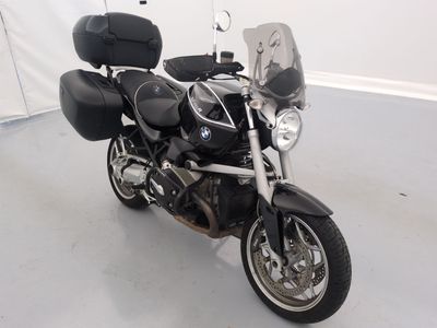 a black motorcycle parked in a room with a white wall
